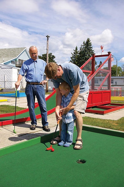 A family playing mini golf